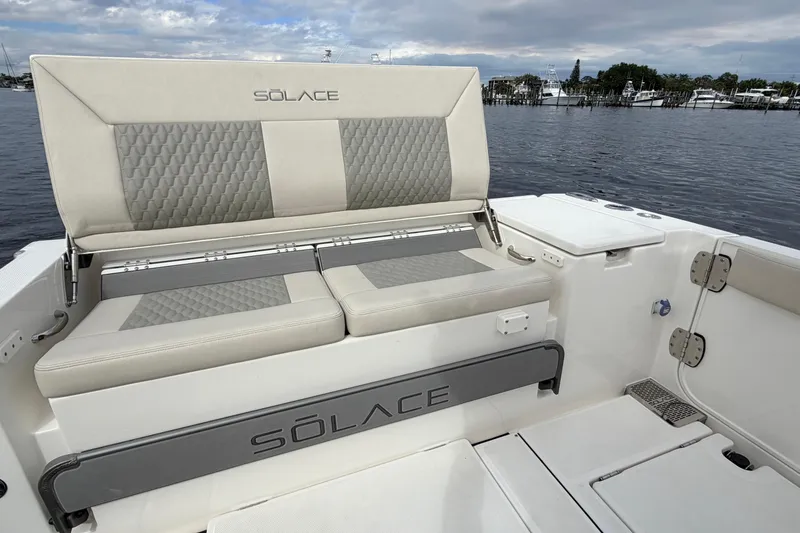 Slide: The Image of 2026 Solace 30 CS boat with cushioned seating, docked by the water. - 21