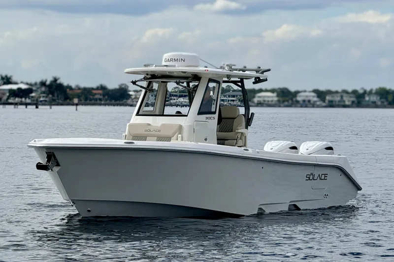 Slide: The Image of 2026 Solace 30 CS boat on calm water, featuring sleek design and twin engines. - 3