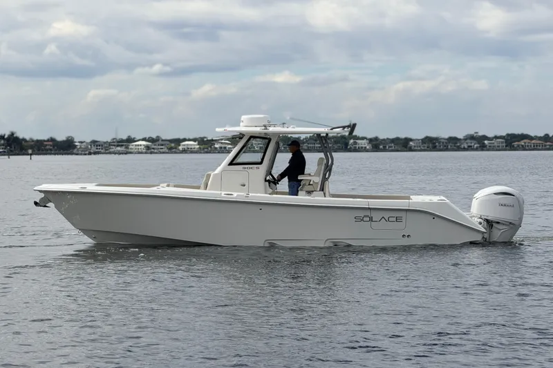 Slide: The Image of 2026 Solace 30 CS boat cruising on calm waters under a cloudy sky. - 5