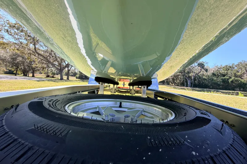 Slide: The Image of Underneath view of a 2011 Hell's Bay Glades Skiff on a trailer with spare tire. - 11