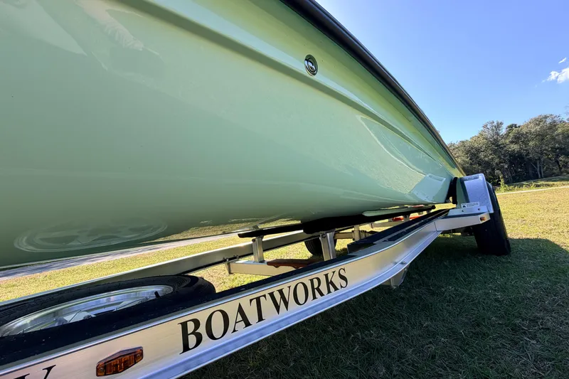 Slide: The Image of 2011 Hell's Bay Glades Skiff on trailer, grassy field, clear sky background. - 12