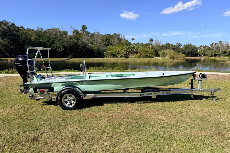 Slide: The Image of 2011 Hell's Bay Glades Skiff on trailer by a scenic lake under blue sky. - 2