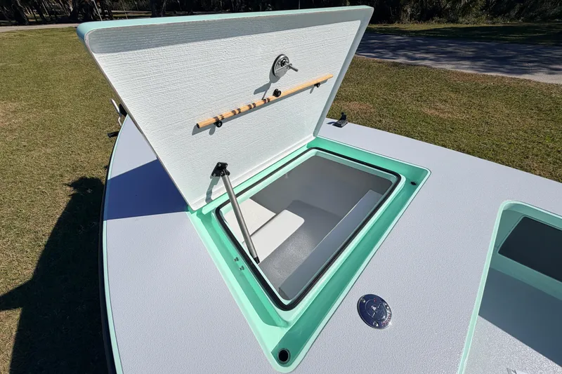 Slide: The Image of Open storage compartment on 2011 Hell's Bay Glades Skiff boat, featuring mint green trim. - 21