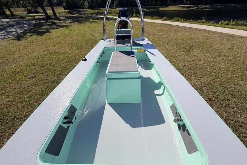 Slide: The Image of 2011 Hell's Bay Glades Skiff boat on grass, showcasing sleek design and open deck. - 28