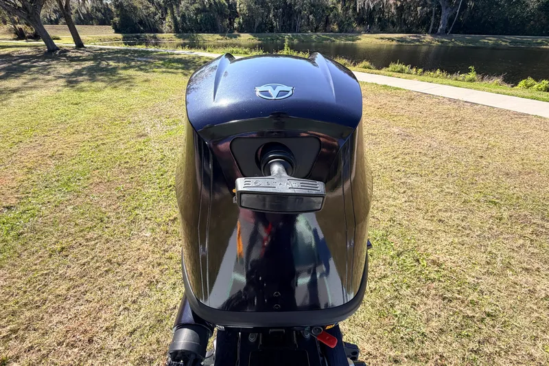 Slide: The Image of Outboard motor of a 2011 Hell's Bay Glades Skiff, parked near a scenic lake. - 49