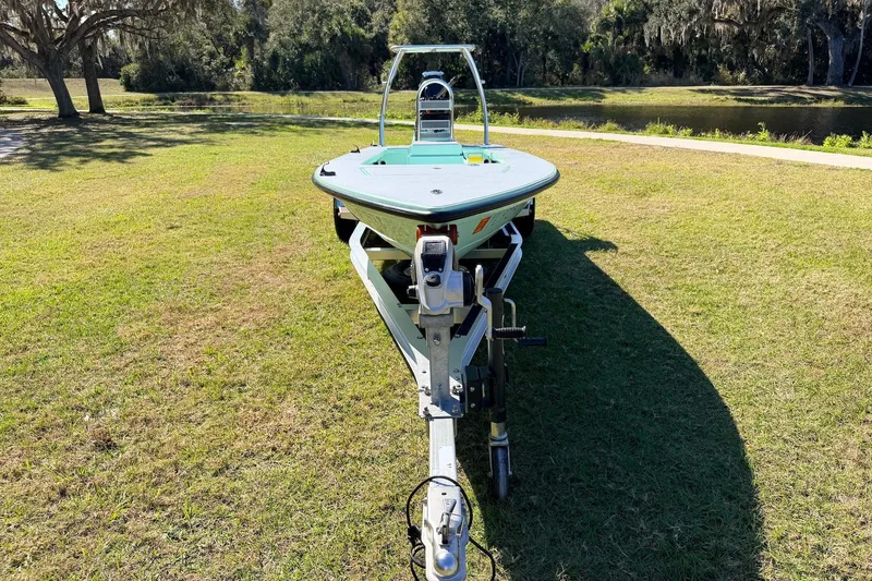 Slide: The Image of 2011 Hell's Bay Glades Skiff on trailer, parked on grassy area near water. - 7