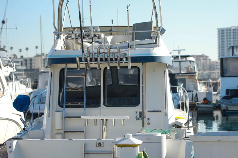 Slide: The Image of 1987 Mediterranean 38 boat docked in a marina, rear view with fishing rods. - 10