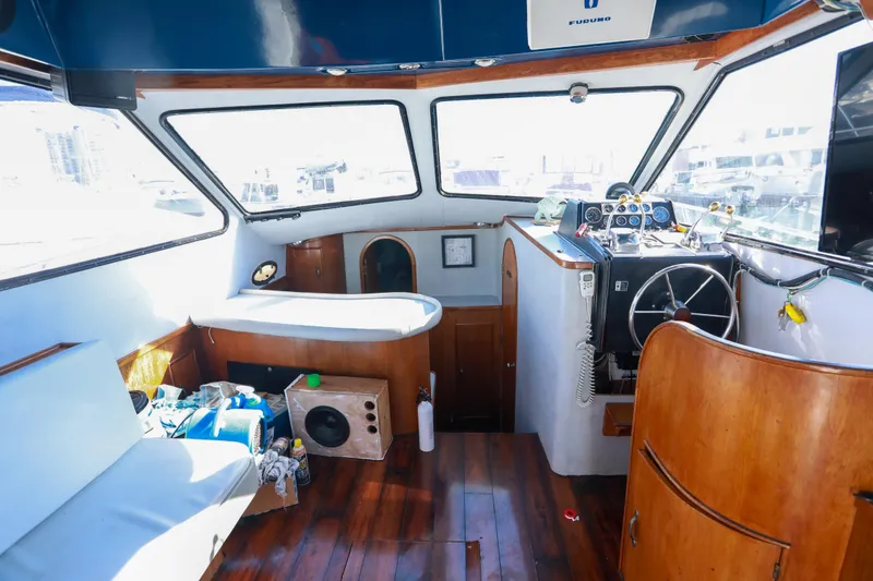 Slide: The Image of Interior of a 1987 Mediterranean 38 boat with wooden flooring and steering console. - 16