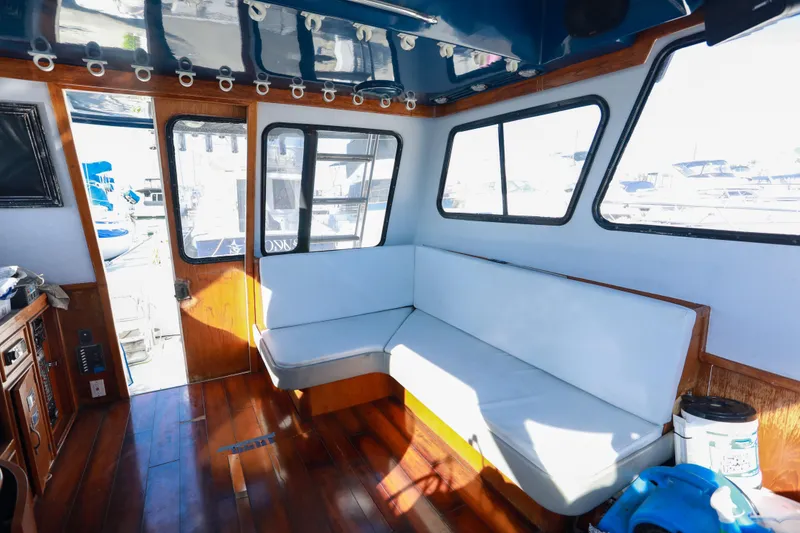 Slide: The Image of Interior of a 1987 Mediterranean 38 boat with wooden flooring and cushioned seating. - 17