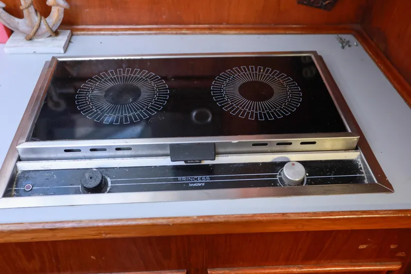 Slide: The Image of Electric stove in a 1987 Mediterranean 38 yacht kitchen, featuring dual burners and wooden cabinetry. - 20