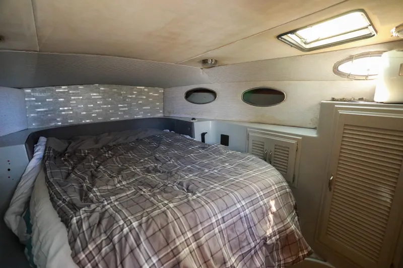 Slide: The Image of Cozy cabin interior of a 1987 Mediterranean 38 boat with plaid bedding and storage. - 22