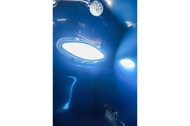 Slide: The Image of Interior view of a 1987 Mediterranean 38 boat with blue lighting and porthole. - 27