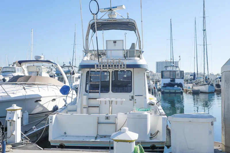 Slide: The Image of 1987 Mediterranean 38 yacht docked in a marina, surrounded by other boats. - 6