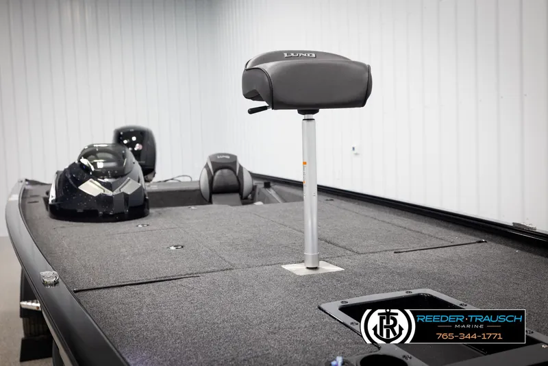 Slide: The Image of 2025 Lund 1975 Renegade boat interior with seating and console, displayed indoors. - 20