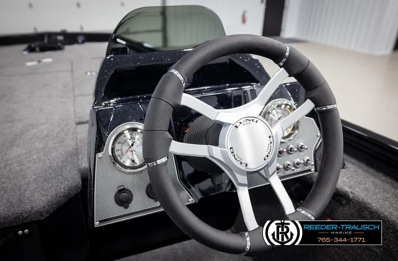 Slide: The Image of Steering wheel of 2025 Lund 1975 Renegade boat, featuring modern dashboard controls. - 26