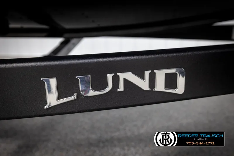 Slide: The Image of Lund 1975 Renegade 2025 model logo on a black surface, Reeder-Trausch Marine branding. - 49