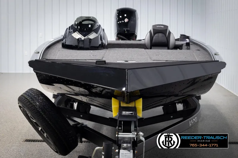 Slide: The Image of 2025 Lund 1975 Renegade boat on trailer in showroom, Reeder-Trausch Marine logo visible. - 6