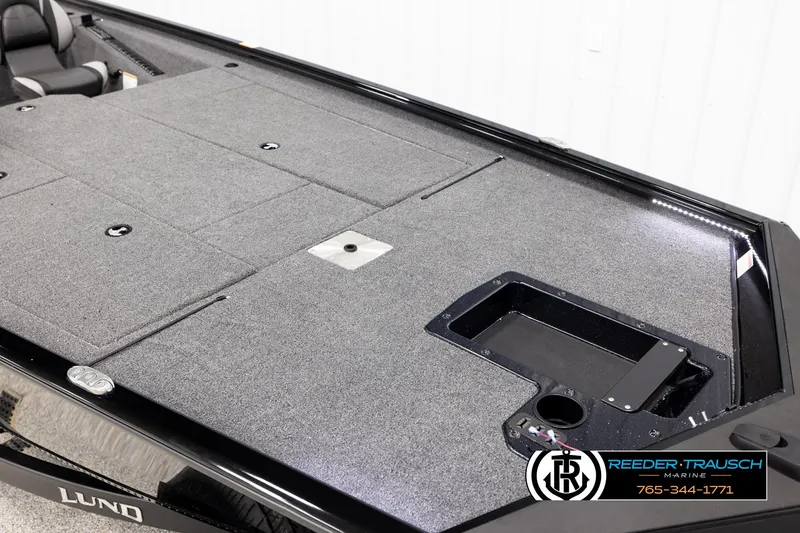 Slide: The Image of 2025 Lund 1975 Renegade boat deck with gray carpet and storage compartments. - 7