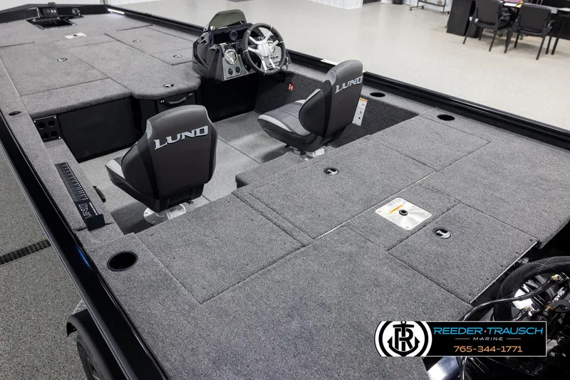 Slide: The Image of 2025 Lund 1975 Renegade boat interior with gray carpet and dual seats, showcased at Reeder-Trausch Marine. - 9