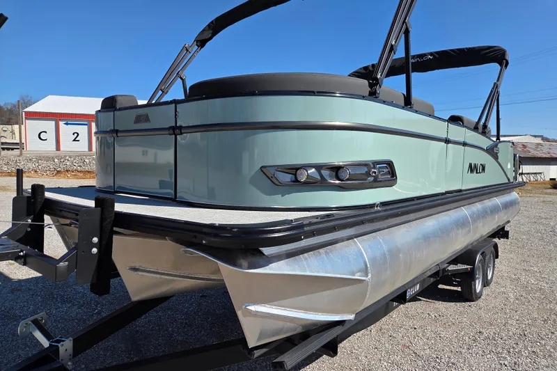Slide: The Image of 2026 Avalon Platinum Catalina 2585 Elite pontoon boat on trailer, outdoor setting. - 2