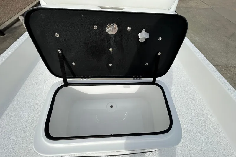Slide: The Image of Open storage compartment on 2018 SCB Recon boat, featuring a black lid and white interior. - 17