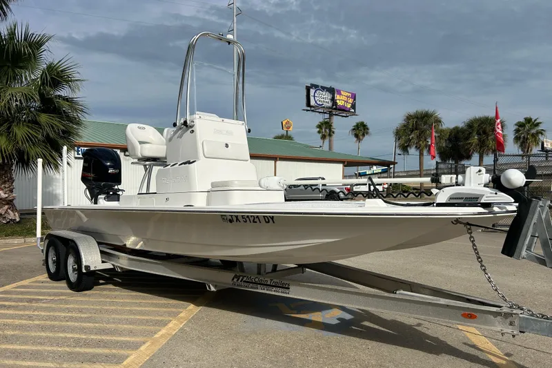 Slide: The Image of 2018 SCB Recon boat on trailer, parked outdoors with palm trees in the background. - 7
