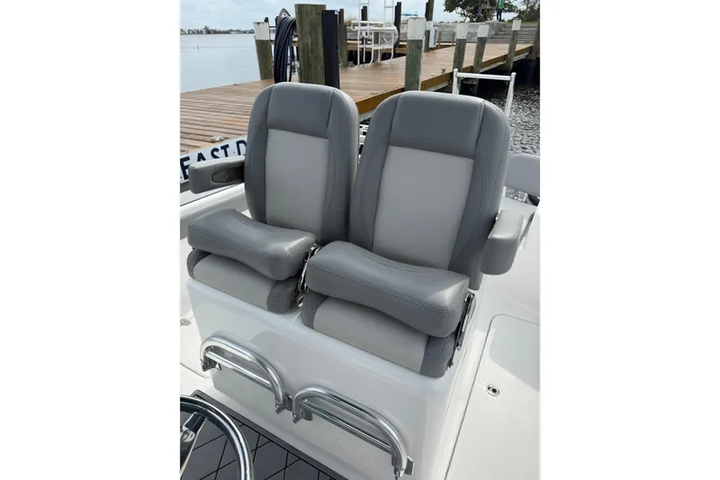 Slide: The Image of Luxury seating on 2026 Falcon Boats 26, featuring dual gray cushioned seats by the dock. - 13