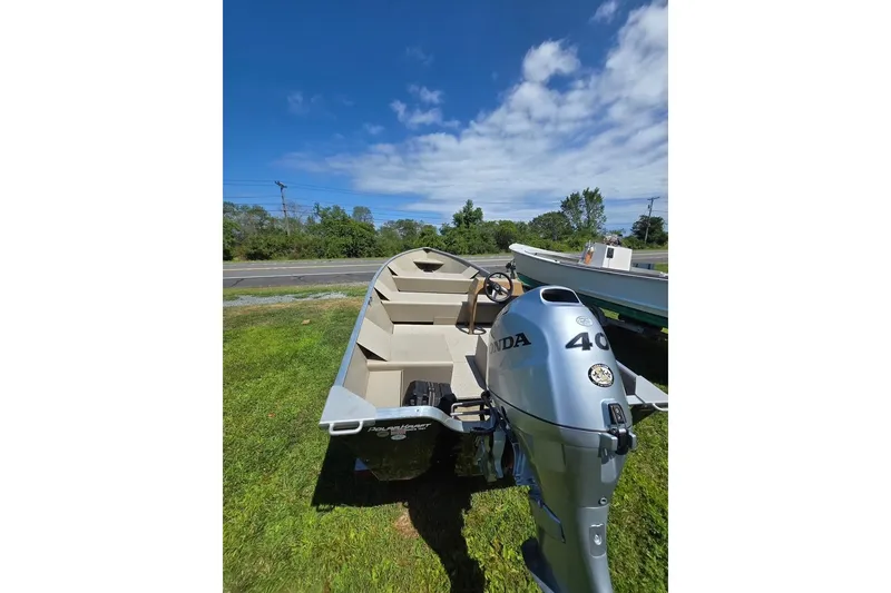 Slide: The Image of 2024 Polar Kraft Dakota boat with Honda 40 outboard motor on grassy area. - 2