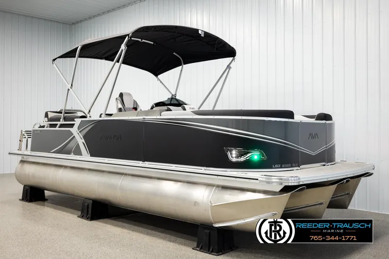 Slide: The Image of 2026 Avalon LSZ QLS pontoon boat with sleek design and canopy in showroom. - 3