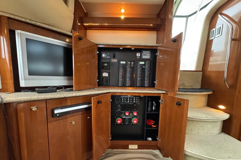 Slide: The Image of 2007 Meridian 459 Motoryacht interior with control panel, TV, and wooden cabinetry. - 10
