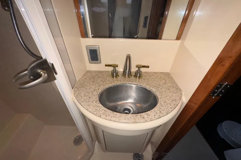 Slide: The Image of Bathroom sink area in 2007 Meridian 459 Motoryacht, featuring granite countertop and stainless steel fixtures. - 17