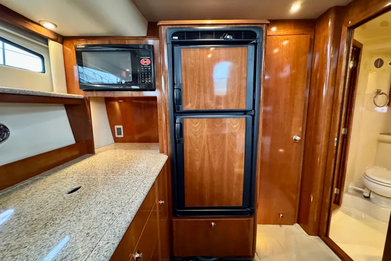 Slide: The Image of 2007 Meridian 459 Motoryacht kitchen with wood cabinetry, granite countertop, and built-in appliances. - 18