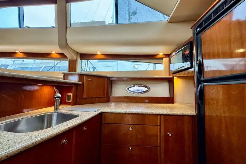 Slide: The Image of Luxurious kitchen interior of 2007 Meridian 459 Motoryacht with wood cabinetry and modern appliances. - 19