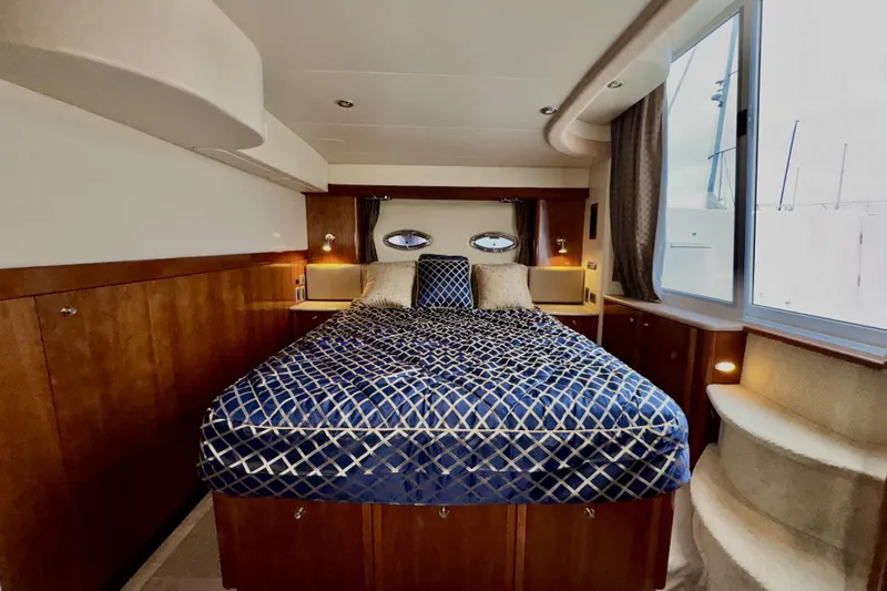 Slide: The Image of Luxurious bedroom interior of 2007 Meridian 459 Motoryacht with elegant bedding and wood accents. - 2