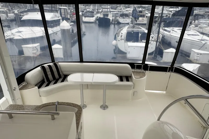Slide: The Image of 2007 Meridian 459 Motoryacht interior with seating area, table, and marina view. - 29