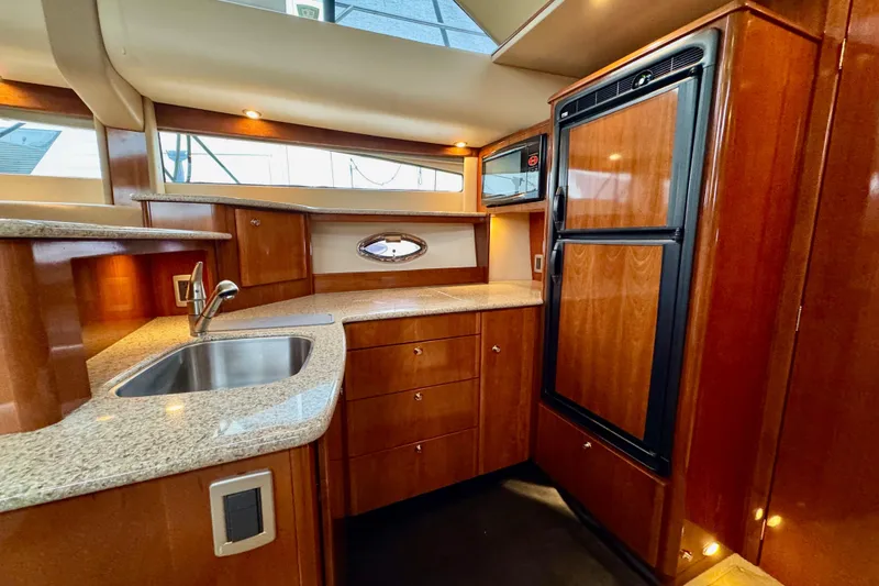 Slide: The Image of Luxurious 2007 Meridian 459 Motoryacht kitchen with wood cabinetry and modern appliances. - 3