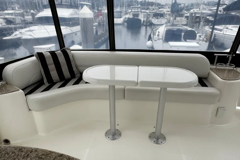 Slide: The Image of 2007 Meridian 459 Motoryacht interior with striped seating and table, overlooking marina. - 30