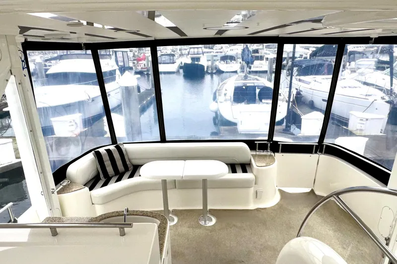 Slide: The Image of Luxurious 2007 Meridian 459 Motoryacht interior with marina view, featuring elegant seating and table. - 32