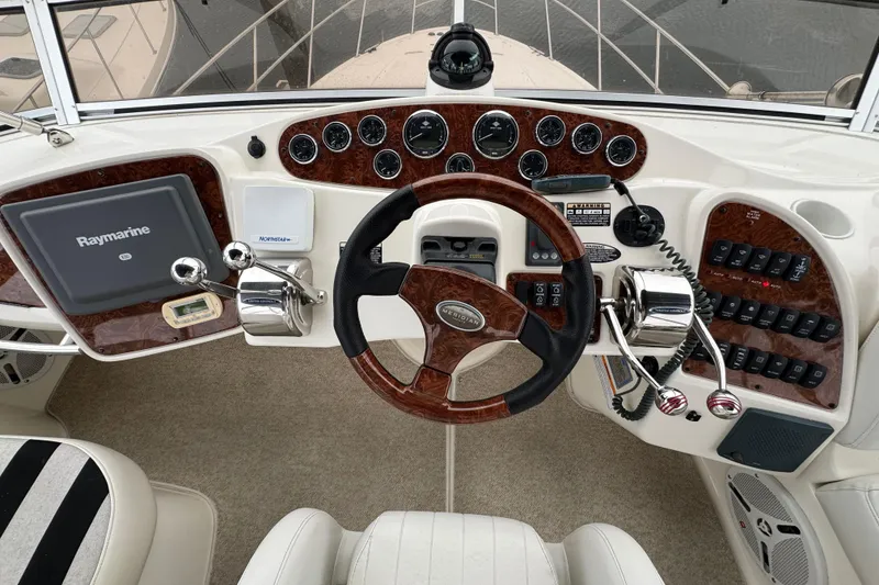 Slide: The Image of 2007 Meridian 459 Motoryacht helm with Raymarine navigation and wood-accented controls. - 33