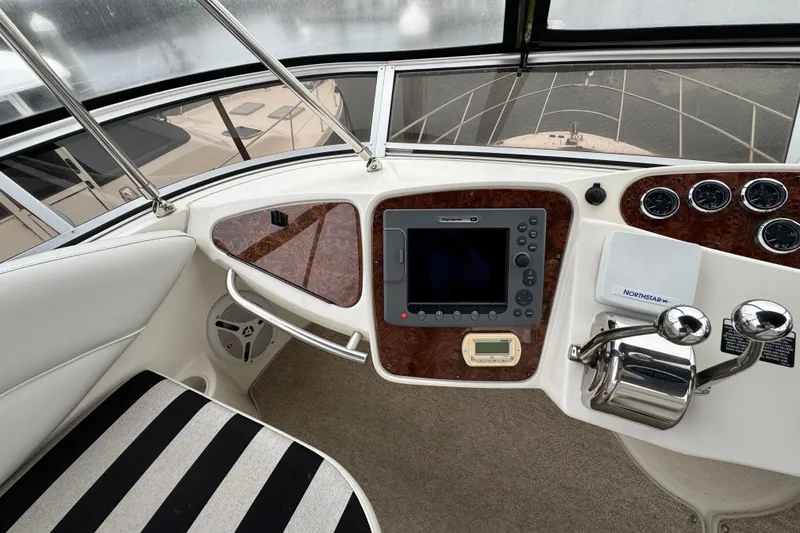Slide: The Image of 2007 Meridian 459 Motoryacht helm with navigation controls and striped seating. - 34
