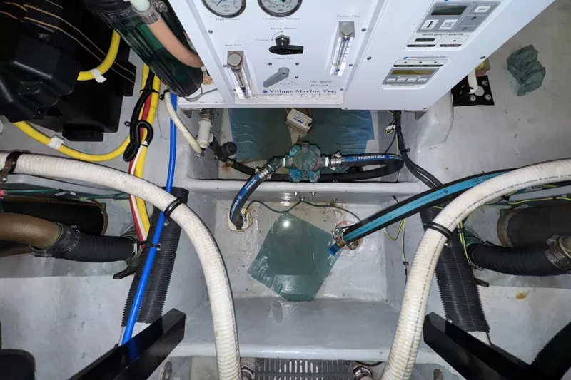 Slide: The Image of Engine room of a 2007 Meridian 459 Motoryacht with various hoses and control panels. - 49