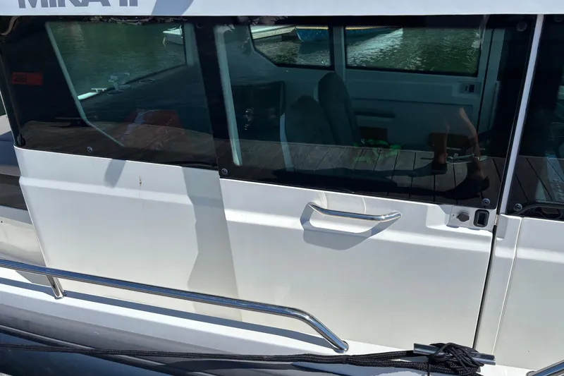 Slide: The Image of 2020 Axopar 29 Aft Cabin boat side view with window and handle. - 10