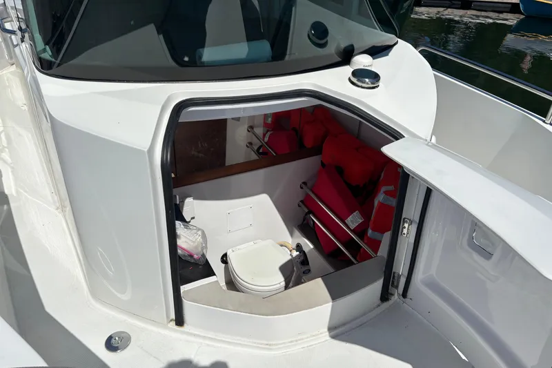 Slide: The Image of 2020 Axopar 29 Aft Cabin interior with life jackets and portable toilet. - 18