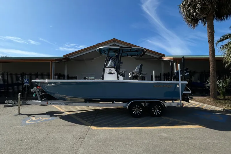 The Image of 2026 Sea Pro 250 Bay boat on trailer, parked outdoors under clear sky. - 0
