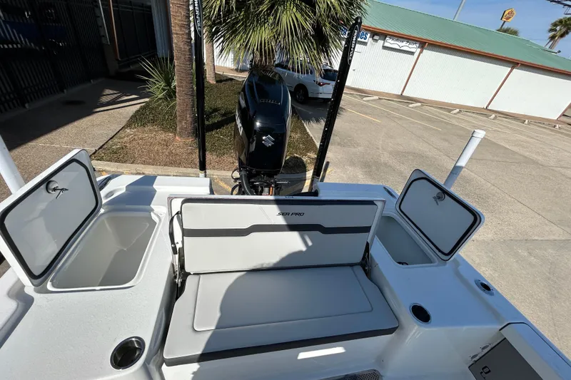 Slide: The Image of 2026 Sea Pro 250 Bay boat interior with storage compartments and Suzuki outboard motor. - 12