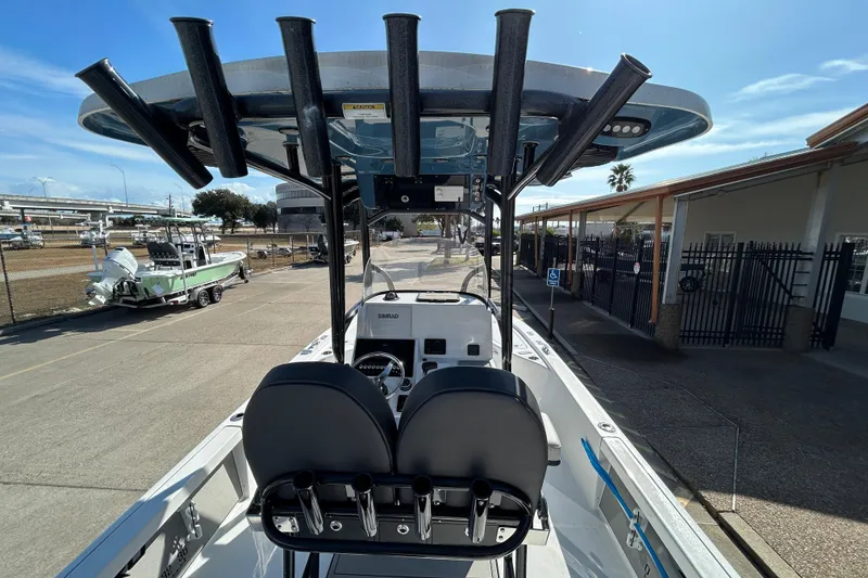 Slide: The Image of 2026 Sea Pro 250 Bay boat with T-top and rod holders, docked at marina. - 14