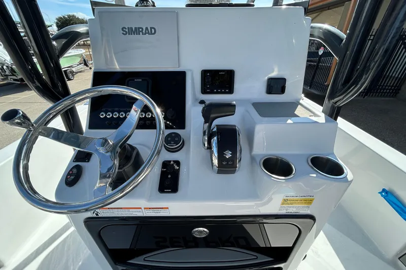 Slide: The Image of 2026 Sea Pro 250 Bay boat console with Simrad electronics and Suzuki controls. - 18