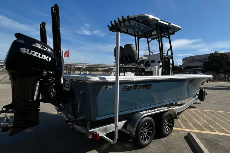 Slide: The Image of 2026 Sea Pro 250 Bay boat with Suzuki engine on trailer, parked outdoors. - 9