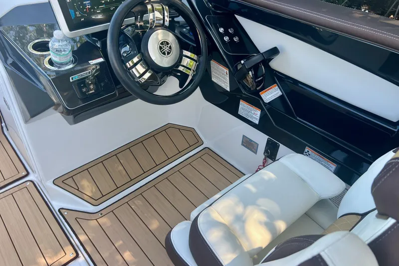 Slide: The Image of 2021 Yamaha Boats 275SD cockpit with steering wheel and control panel. - 10
