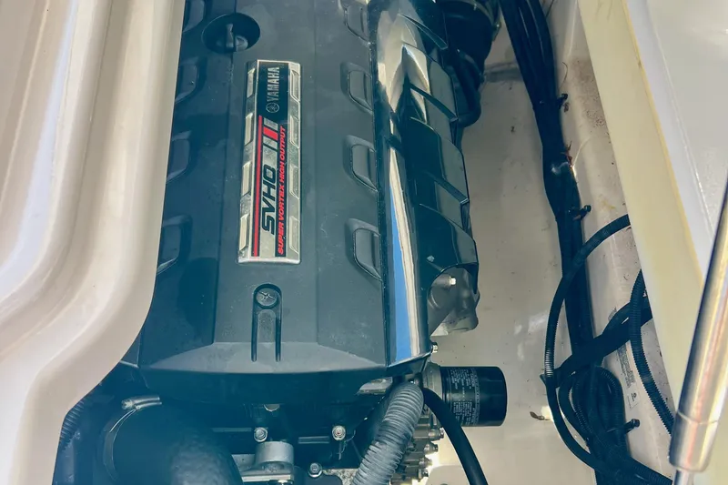 Slide: The Image of 2021 Yamaha Boats 275SD in water, sleek design, white and maroon color, docked by greenery. - 3